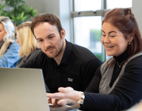Man and woman looking at a laptop screen.